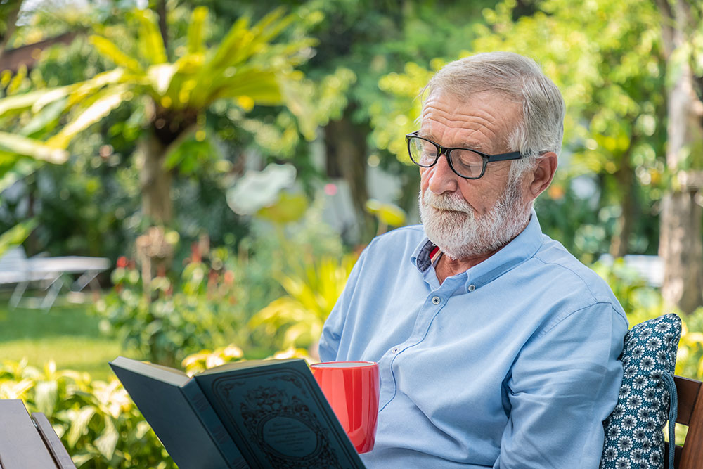 Ocean Hills Senior Living senior man reading book outside