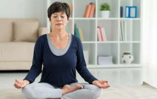 Ocean Hills Senior Living senior woman meditating in living room