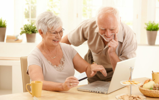 Senior couple looking at laptop smiling