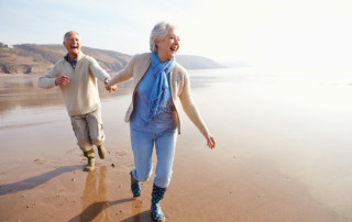 Happy senior couple walking on beach in Oceanside, CA