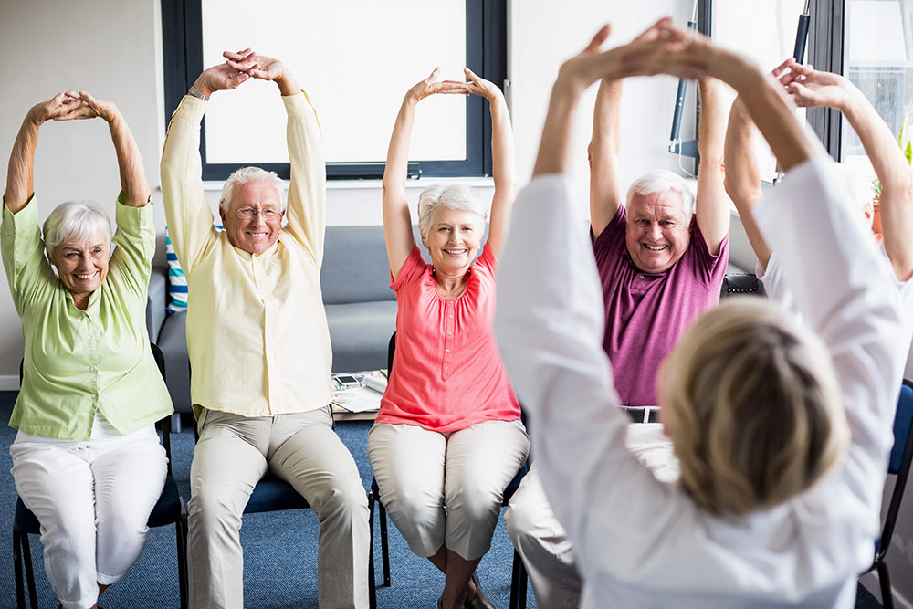 Senior fitness class doing chair yoga