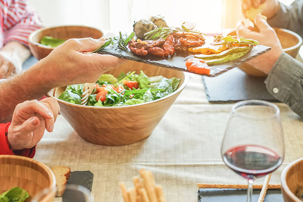 Close up of plate with healthy foods being passed at dinner