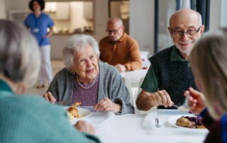 A group of senior friends having lunch together in an assisted living community.