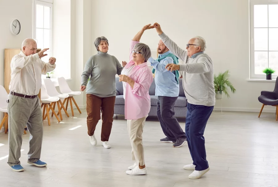 Happy group of seniors dancing in a senior living community class